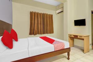 a bedroom with a bed and a desk and a television at Hotel O HRR Hotels Near Paradise circle in Hyderabad