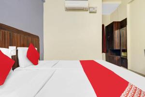 a red and white bed in a room at Hotel O HRR Hotels Near Paradise circle in Hyderabad