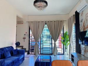 a living room with a blue couch and a chandelier at EQAMEL Homestay Corner Lot in Sandakan
