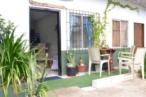 a patio with chairs and a table with plants at Casa Albacora in Puerto Baquerizo Moreno