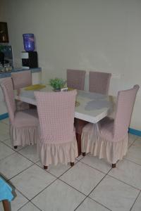 ein Esstisch mit rosa Stühlen und ein Tisch mit in der Unterkunft Casa Albacora in Puerto Baquerizo Moreno