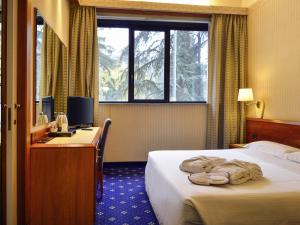 Ένα ή περισσότερα κρεβάτια σε δωμάτιο στο Mercure Reggio Emilia Centro Astoria