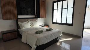 a bedroom with a bed and two windows at Light Star Kuta Lombok in Kuta Lombok