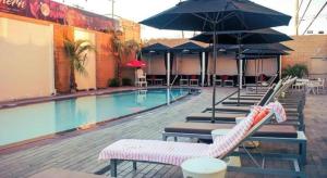 a swimming pool with lounge chairs and umbrellas at Ahern Hotel and Event Center in Las Vegas