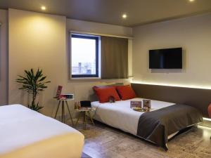 Ένα ή περισσότερα κρεβάτια σε δωμάτιο στο Mercure Porto Centro Santa Catarina