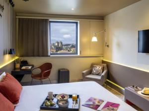 a hotel room with a bed and a window at Mercure Porto Centro Santa Catarina in Porto +190 photos