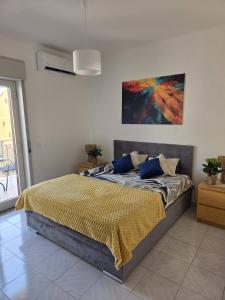 a bed in a bedroom with a painting on the wall at Due Sorelle in Santa Teresa di Riva