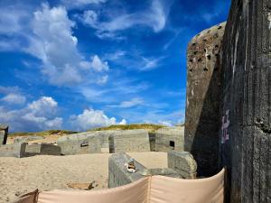 a stone building on a beach with a blue sky at Tranquil Retreat in Thorsminde-By Traum in Ulfborg