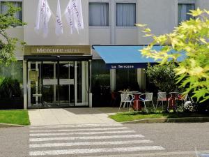 ein Hotel mit einem Tisch und Stühlen davor in der Unterkunft Mercure Hotel Forbach Centre de Loisirs in Forbach