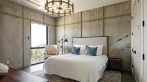 a bedroom with a large white bed and a chair at Belleza by AvantStay Hilltop Mansion w Pool Panoramic Views Ultra Modern Interior in Glen Ellen +88 photos