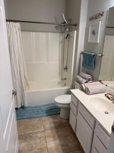 Un baño con bañera, inodoro y lavabo. en 3BD 3BA Gated Condo LakeFront Lake Ozark, MO Isla Del Sol 4 M from Dam, en Rocky Mount