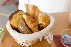 a basket of bread and pastries on a table at Grand Hôtel Filippo Strasbourg Nord in Niederbronn-les-Bains +55 photos