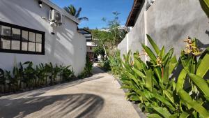 a sidewalk next to a white building with plants at Light Star Kuta Lombok in Kuta Lombok