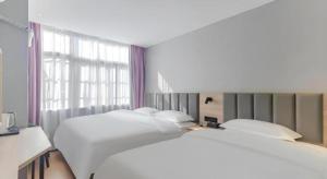 a bedroom with two beds and a large window at Shell Hotel Hefei Provincial Hospital in Hefei +50 photos