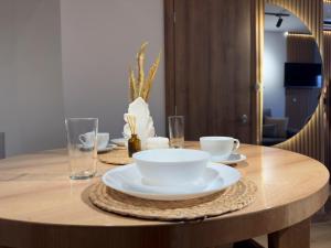 a wooden table with plates and bowls on it at Apartamento de lujo rodadero in Santa Marta