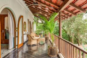 an outdoor porch with wicker chairs and a table at La Dona by The Blue Kite - 4BHK Private Pool Villa in Assagao with Garden, Balcony, Caretaker & Spacious Living Area in Assagao
