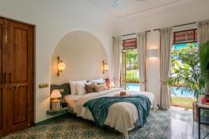 a bedroom with a large bed and a large window at La Dona by The Blue Kite - 4BHK Private Pool Villa in Assagao with Garden, Balcony, Caretaker & Spacious Living Area in Assagao