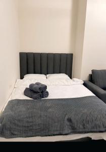a bed with a black headboard and towels on it at Apartment tsaghkadzor SHINE HOME in Tsaghkadzor