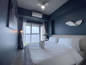 ein Schlafzimmer mit einem weißen Bett mit einer blauen Wand in der Unterkunft 90 Sqm Perfect Seaview Luxurious Modern 2 Bedrooms, Nearby Okada, Solaire, Airports, MOA with Free Parking in Manila + 24 Fotos