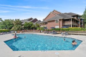 a swimming pool with two children playing in the water at Kingston Plantation - Richmond Park #7E in Myrtle Beach