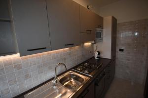 a kitchen with a sink and a stove at A casa di Gina in Airasca