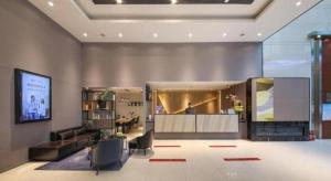 a lobby of a hotel with a bar in the center at City Comfort Inn Hotel Wuhan Optics Valley Square Metro Station Zhongnan Minzu University in Wuhan