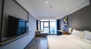 a bedroom with a large bed and a flat screen tv at 7 Days Premium Hotel Chongqing Jiangbei International Airport Terminal 3 in Chongqing