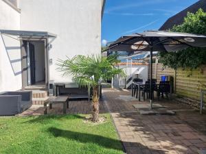 a patio with a palm tree and an umbrella at Bei Pina - Business apartment nahe Düsseldorf in Solingen