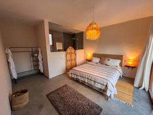 a bedroom with a large bed and a chandelier at Villa Amwaj 15 min from Essaouira & Sidi Kaouki in Essaouira +28 photos