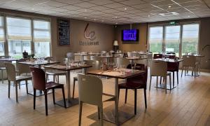 a dining room with tables and chairs in a restaurant at Campanile Chambéry in Chambéry