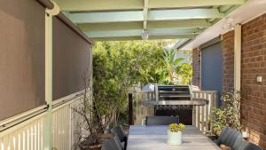 a patio with a table and chairs and a grill at 2-5 The Meridian, Corlette in Corlette
