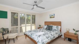 a bedroom with a bed and a chair and a window at 2-5 The Meridian, Corlette in Corlette