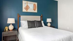 une chambre avec un lit aux murs bleus et deux lampes dans l'établissement Landing Beautiful 2BD Clubhouse Gym, à Betzwood 38 autres photos