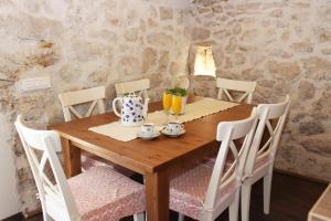 una mesa de madera con sillas y un set de té. en Holiday Home Cvita, en Lozovac