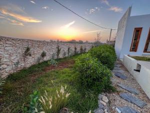 a stone wall with the sunset in the background at Villa Amwaj 15 min from Essaouira & Sidi Kaouki in Essaouira