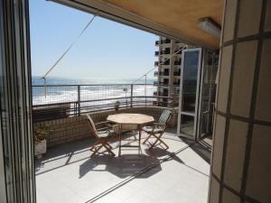 d'un balcon avec une table et des chaises et une vue sur l'océan. dans l'établissement Apartamentos Raymar, à Oropesa del Mar