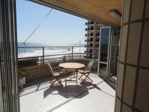 a balcony with a table and chairs and a view of the ocean at Apartamentos Raymar in Oropesa del Mar