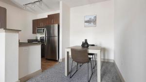 Una cocina con una mesa y un refrigerador de acero inoxidable. en Landing Chic 1BD Clubhouse Gym, en Gruene