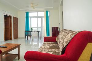 a living room with a red couch and a table at Shree Varahi HomeStay in Tirupati