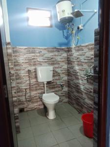a bathroom with a toilet and a brick wall at Eton Homestay in Dirang Dzong