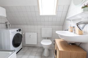 a white bathroom with a toilet and a sink at Kleines Studioapartment direkt am Marktplatz in Heide