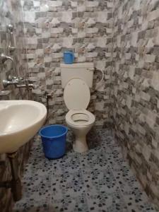 un baño con inodoro y lavabo en Samaira Guest House, en Colva
