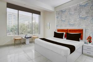 a bedroom with a large bed and a large window at Super Hotel O Sector 51 Metro Station Formerly Shubham Residency in Indirapuram