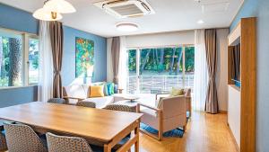 a living room with a table and chairs at Seagaia Forest Cottages in Miyazaki