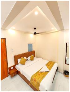 a bedroom with two beds and a ceiling at HOTEL BNK GRAND Near Goḏawalia Chauraha - 100 Meter From Baba Vishwanath Temple & Ganga Arti Ghat ! Wi-Fi #Lift #Hygiene & Spacious Room - BEST HOTEL IN VARANASI in Varanasi