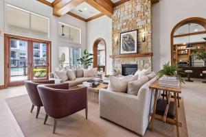 a living room with couches and a stone fireplace at Landing Amazing 1BD Gym in Webster