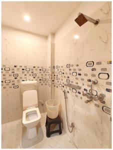 a bathroom with a toilet and a shower at HOTEL BNK GRAND Near Goḏawalia Chauraha - 100 Meter From Baba Vishwanath Temple & Ganga Arti Ghat ! Wi-Fi #Lift #Hygiene & Spacious Room - BEST HOTEL IN VARANASI in Varanasi