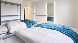 a white bed with a blue blanket on top of it at Tabarja Heights in ‘Ayn aş Şughayrah +122 photos