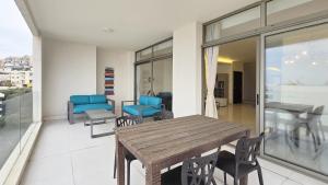 Una habitación con una mesa y sillas de madera en un balcón. en Tabarja Heights, en ‘Ayn aş Şughayrah