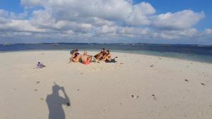 a group of people sitting on a beach at Madak ekas homestay 2 in Ekas +5 photos